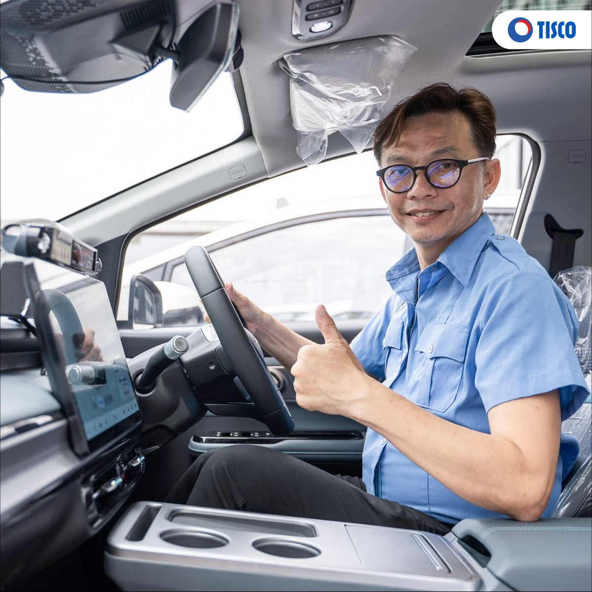ผู้ขับขี่แท็กซี่ไฟฟ้า MGO EV Taxi ชูนิ้วโป้งในห้องโดยสาร